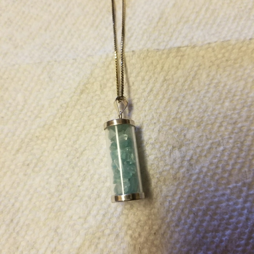 Silver necklace with pieces of jade in it.